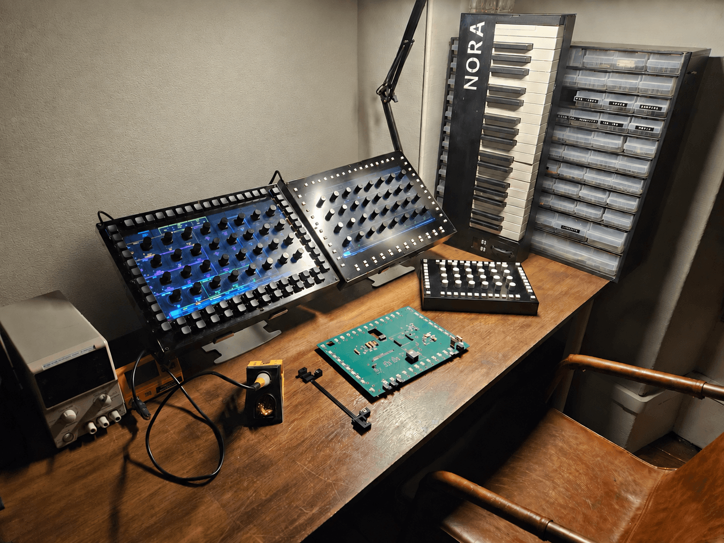 Two prototype control surfaces on the bench, next to a bare board and a soldering iron